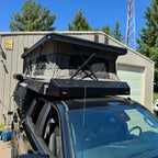 cascadia overland co apex truck camper on a silverado with the pop up tent open